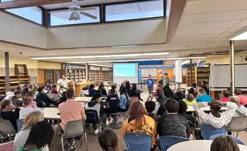 Large assembly of students at a conference presentation