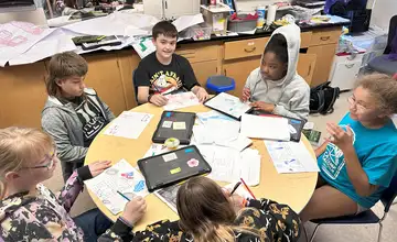Students collaborating around a table on a group project